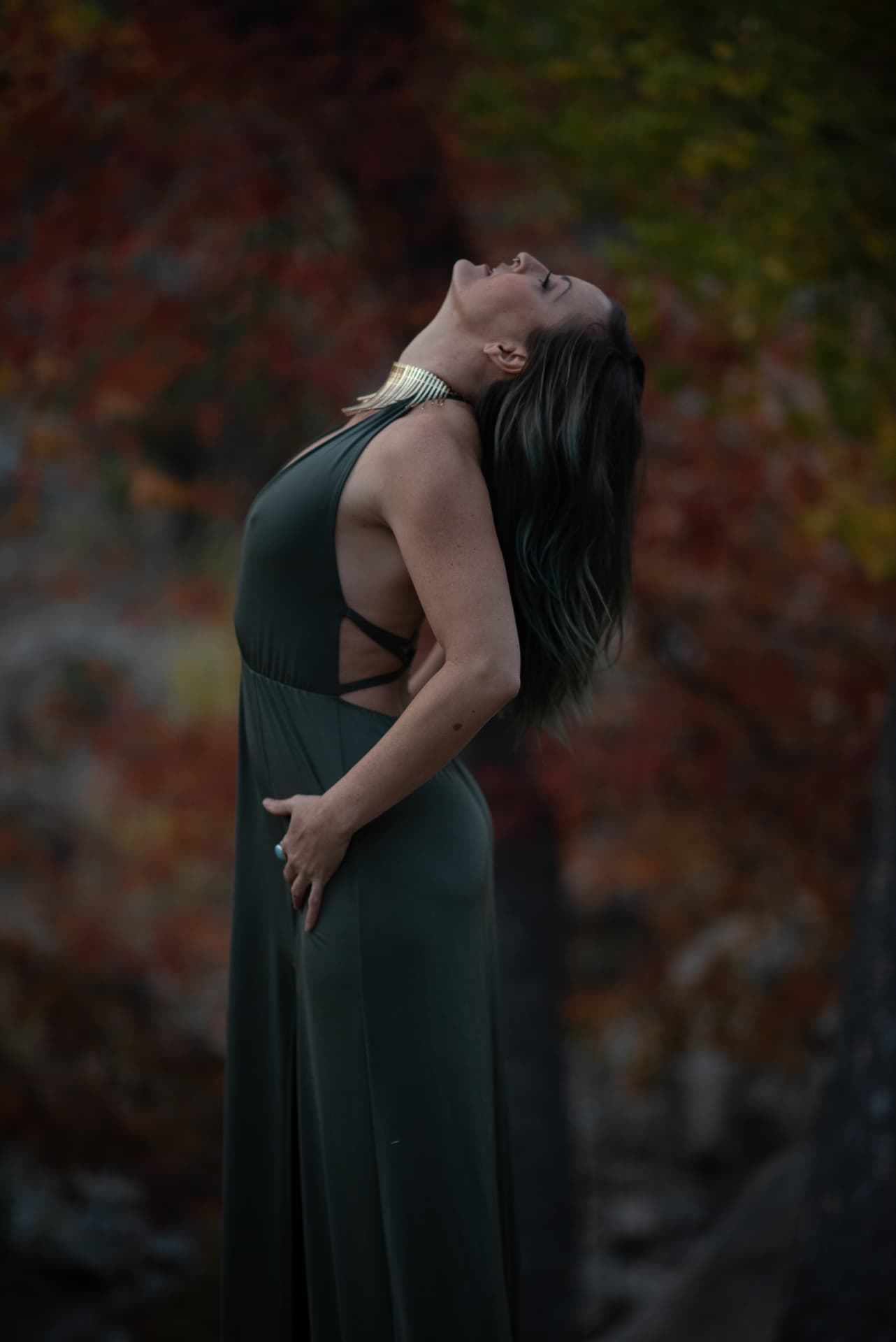 Jenna with her head tipped back among autumn colour