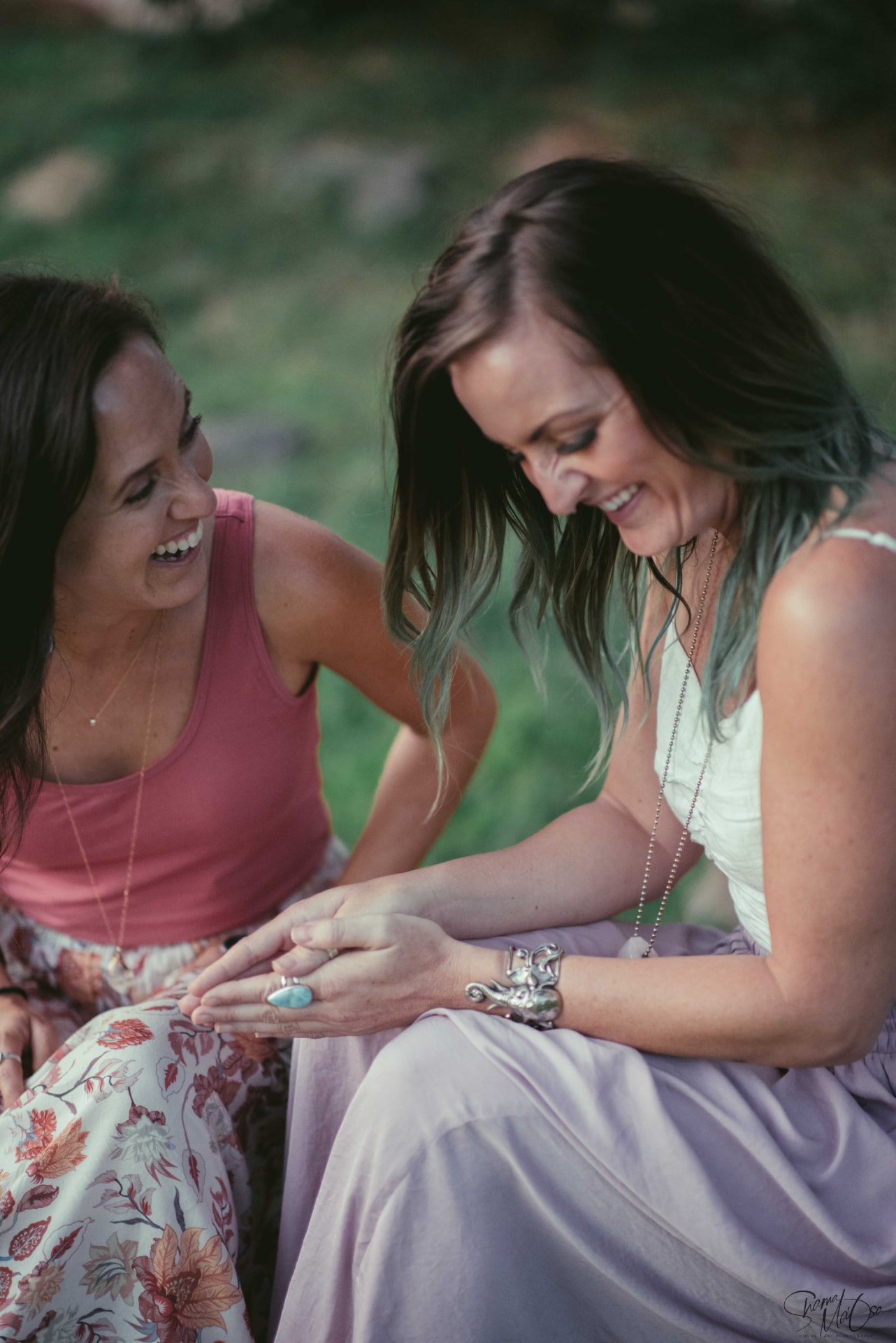 Two women sitting outdoors together, laughing