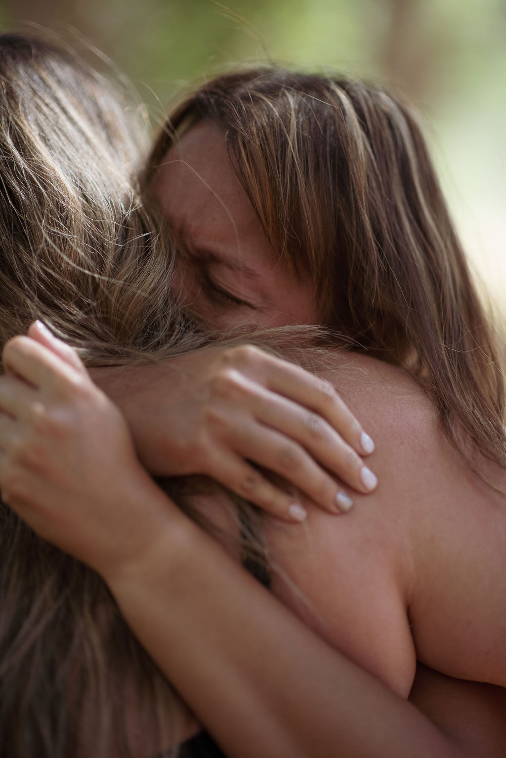 Two women holding each other in an emotional hug