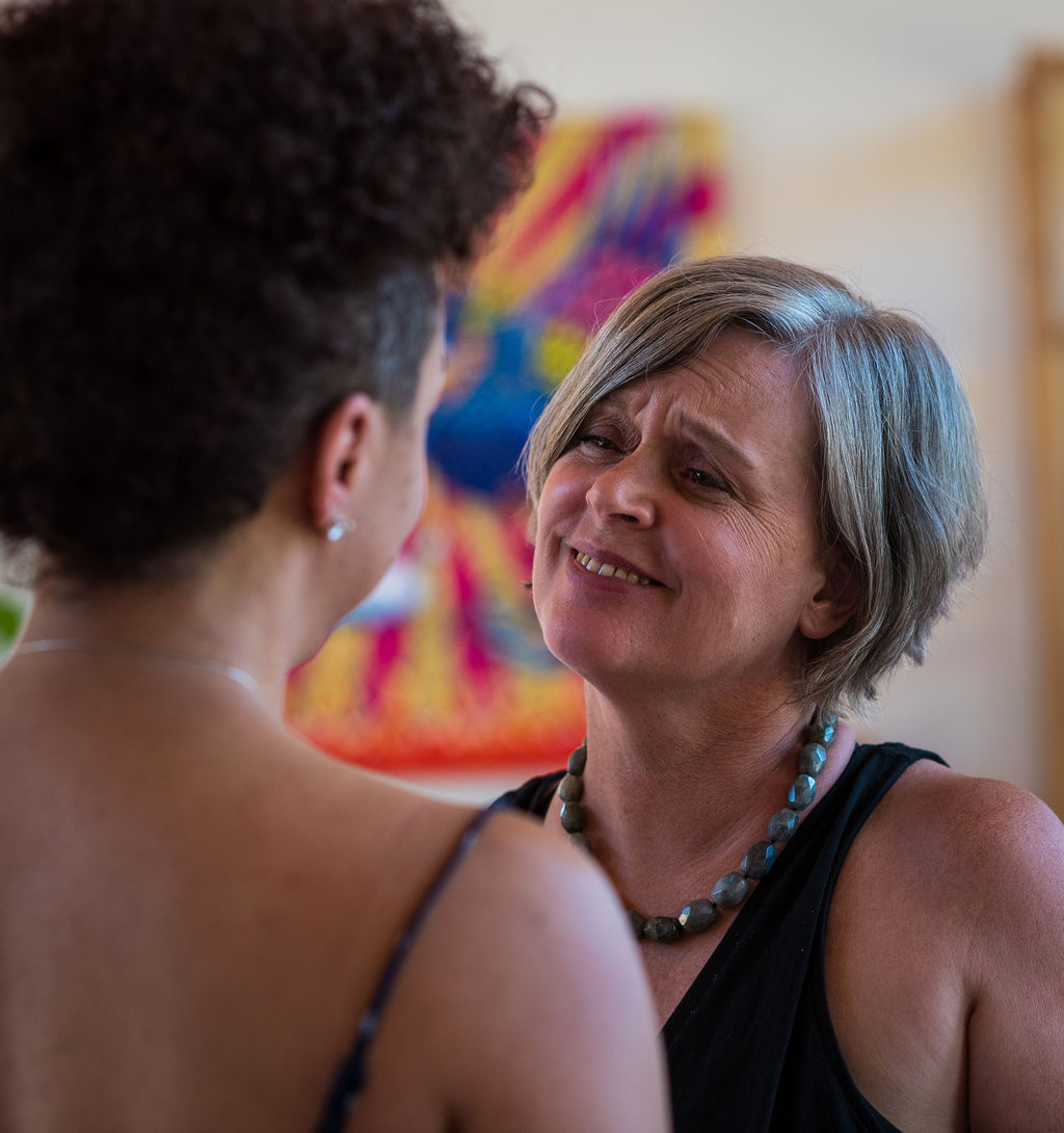 Two women in conversation, one looking warmly at the other